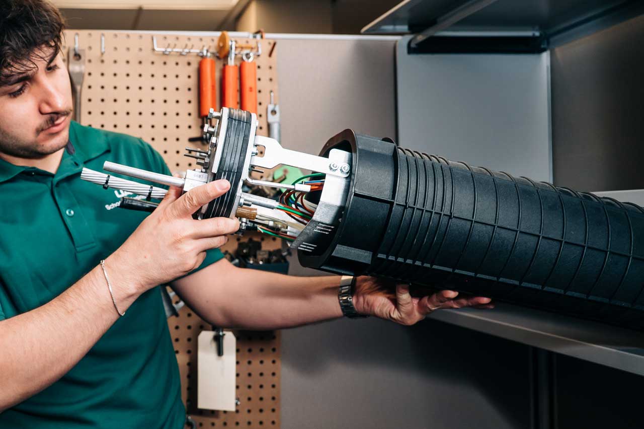 Daniel Hollingsworth inspects wiring inside a utility pole component.